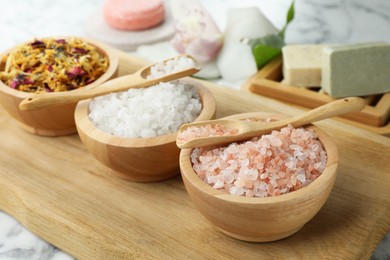 Photo of Spa composition with sea salt and dry flowers in bowls on table