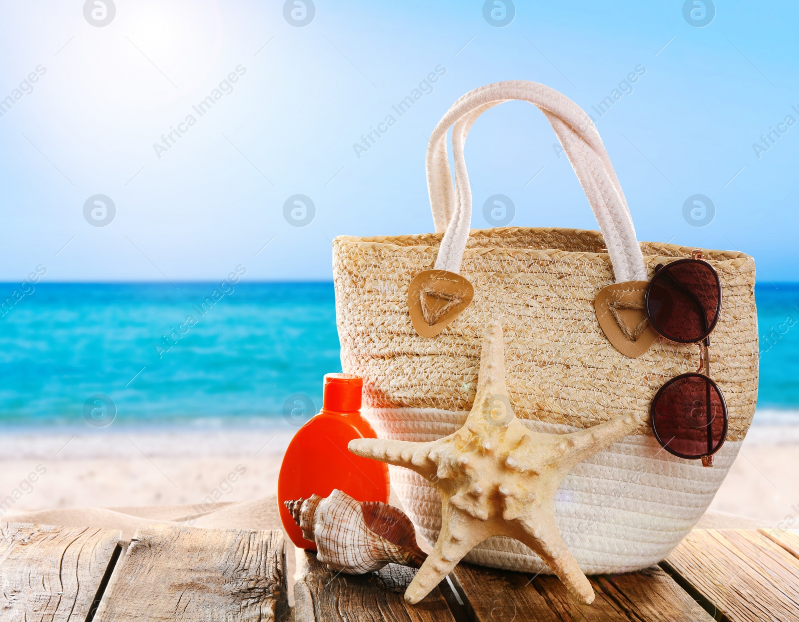 Image of Beach accessories on wooden surface near ocean 