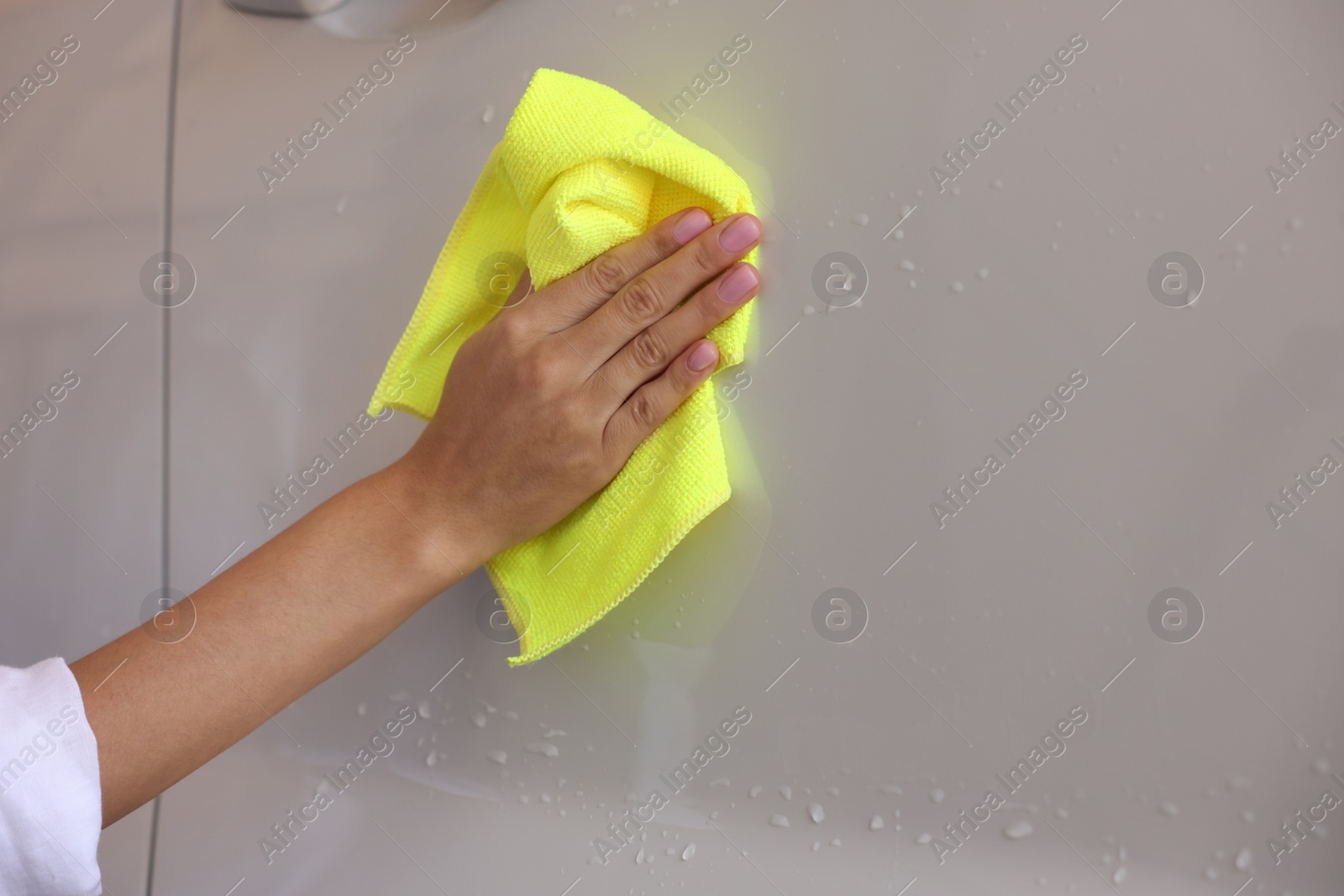 Photo of Woman cleaning car with rag, closeup view