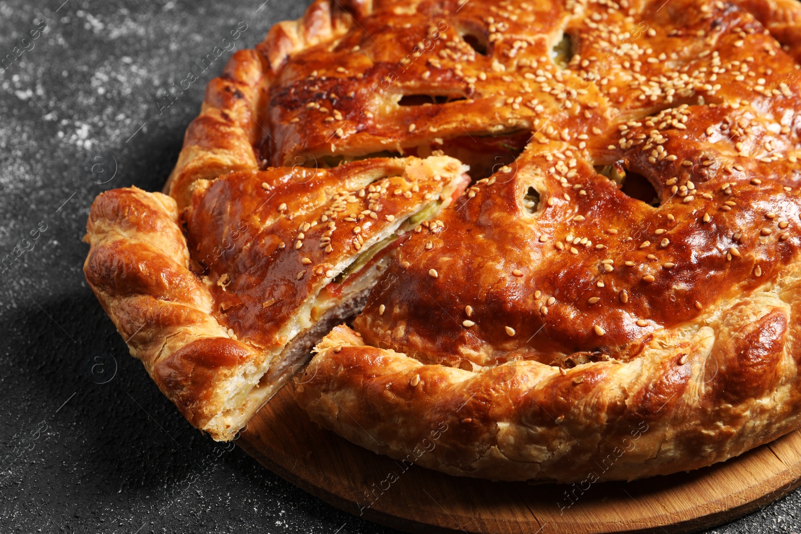 Photo of Cut delicious homemade pie on black table, closeup