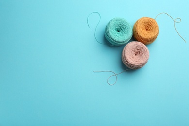 Photo of Clews of knitting threads on color background, flat lay with space for text. Sewing stuff