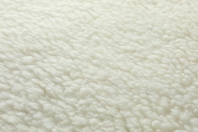 Texture of white fleece fabric as background, top view