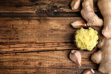 Photo of Fresh garlic and other natural cold remedies on wooden table, flat lay. Space for text