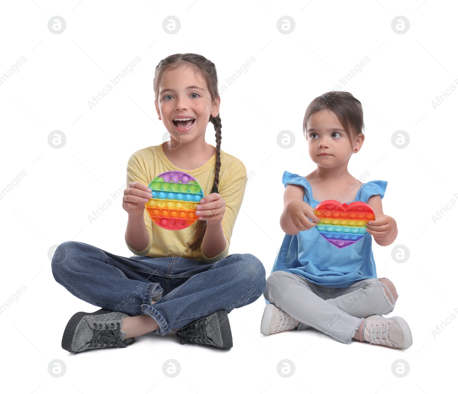 Photo of Little girls with pop it fidget toys on white background