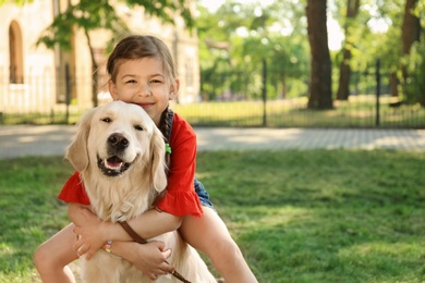 Photo of Cute little child with his pet in green park