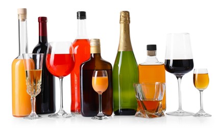 Photo of Bottles and glasses with different alcoholic drinks isolated on white