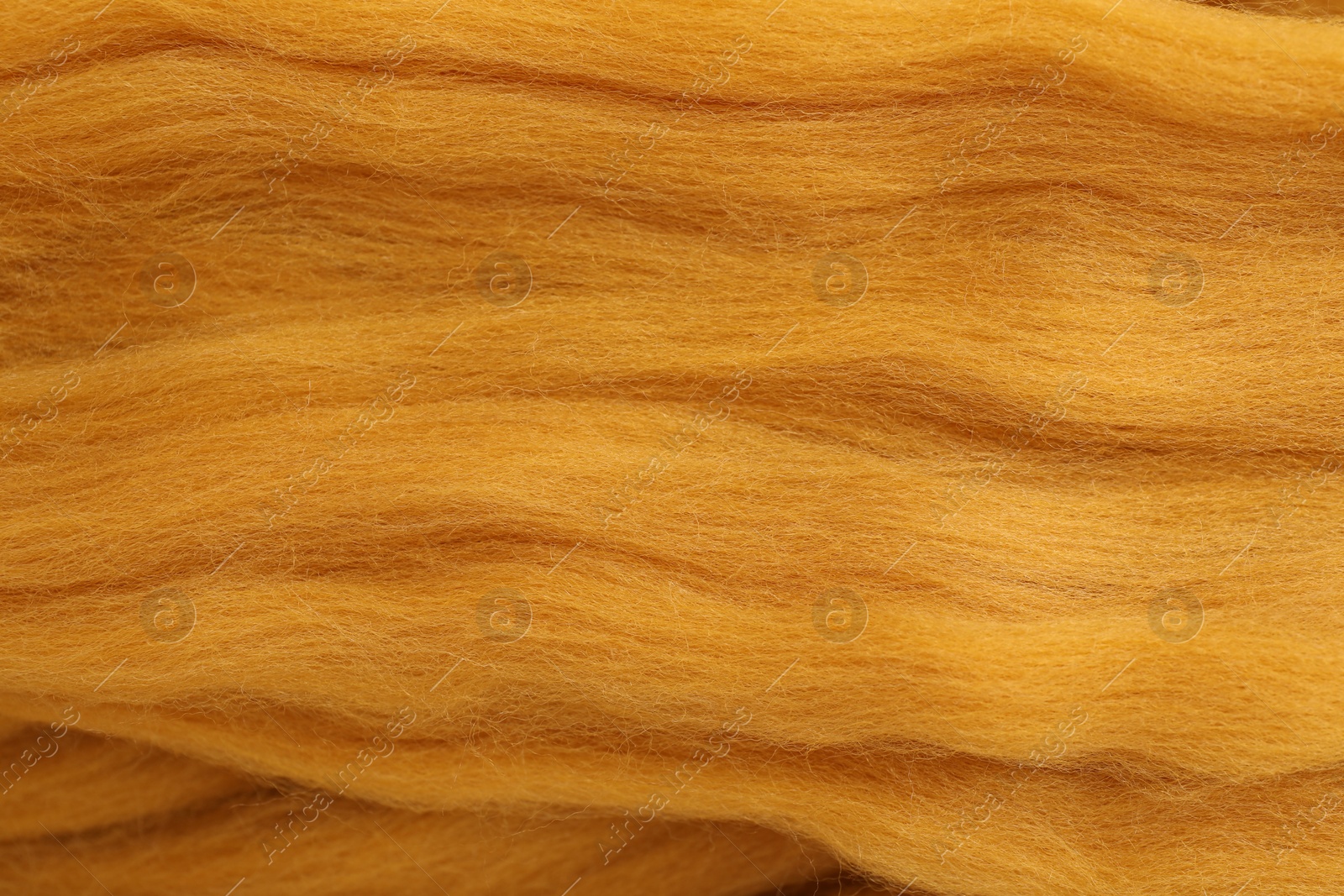 Photo of Orange felting wool as background, closeup view