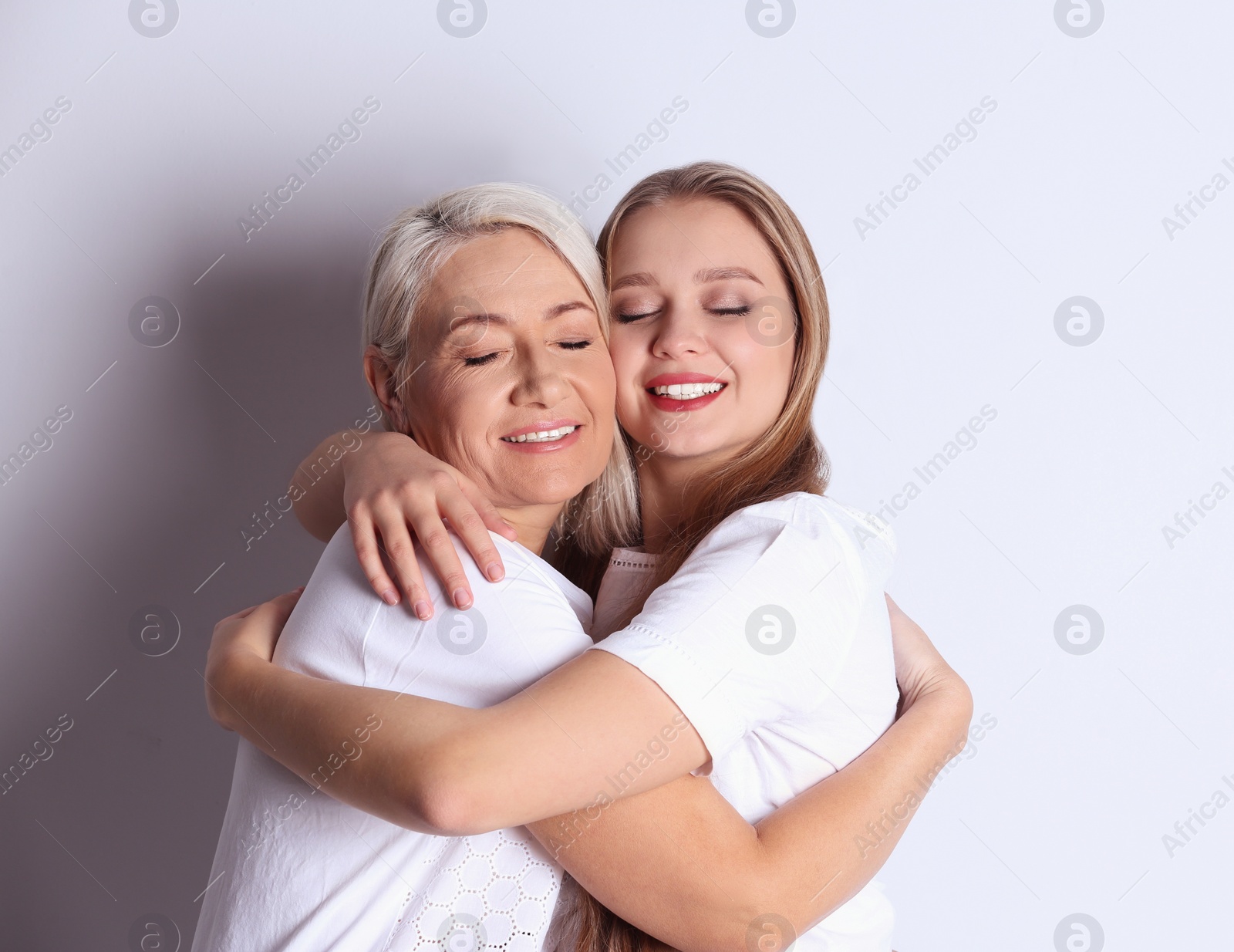 Photo of Mother and her adult daughter on white background