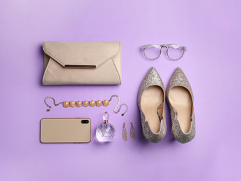 Flat lay composition with stylish woman's bag and accessories on violet background