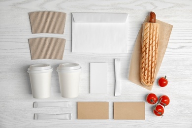 Photo of Flat lay composition with items for mock up design on wooden background. Food delivery service