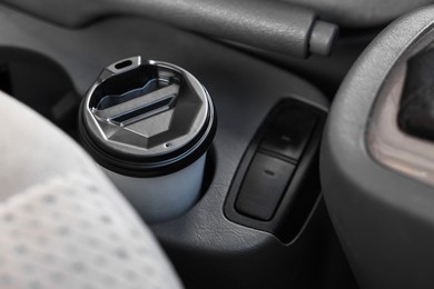 Photo of Coffee to go. Paper cup with tasty drink in holder inside of car, closeup