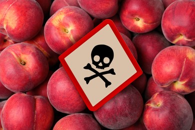 Image of Skull and crossbones sign on ripe peaches, top view. Be careful - toxic