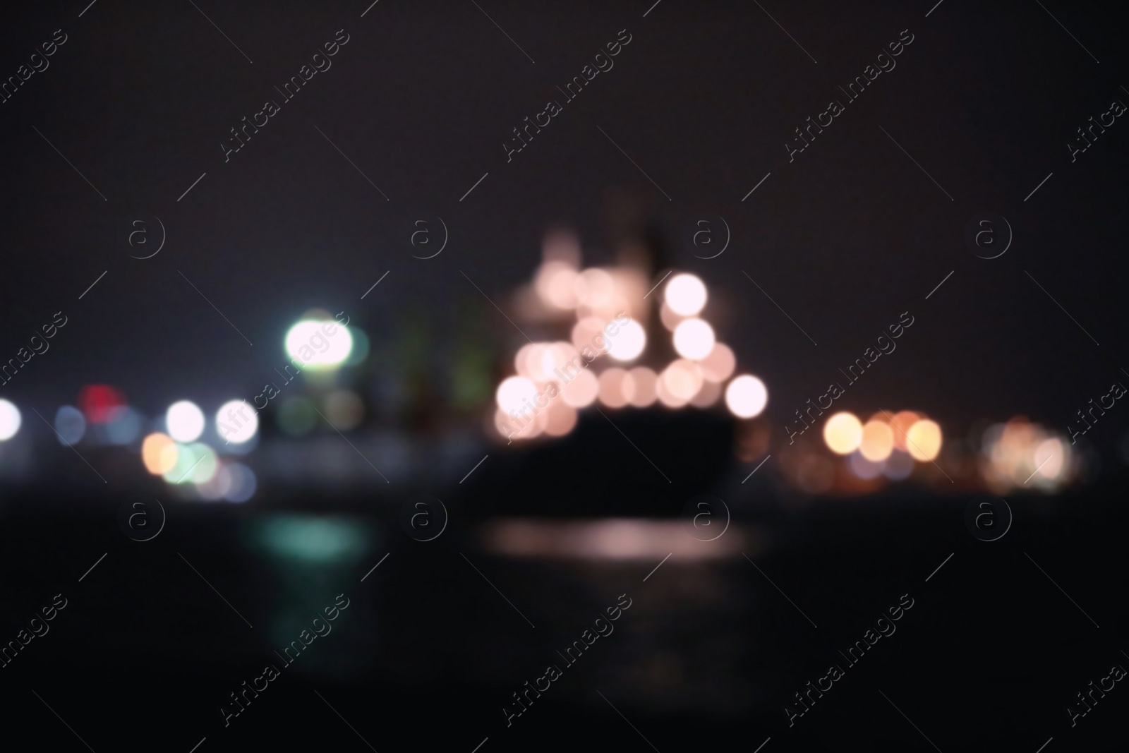 Photo of Blurred view of bulk carrier in roads at night. Bokeh effect