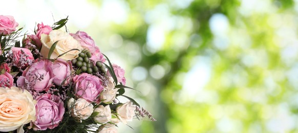 Beautiful bouquet with roses outdoors on sunny day, space for text. Banner design