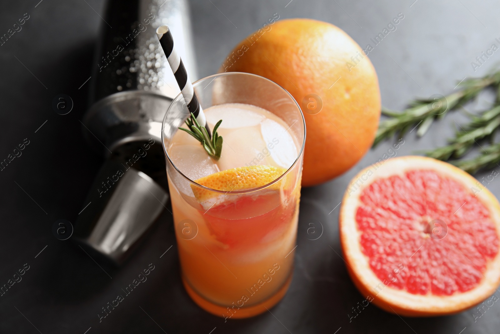 Photo of Composition with glass of grapefruit cocktail on dark table