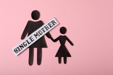 Photo of Being single mother concept. Woman with her child made of paper on pink background, flat lay and space for text