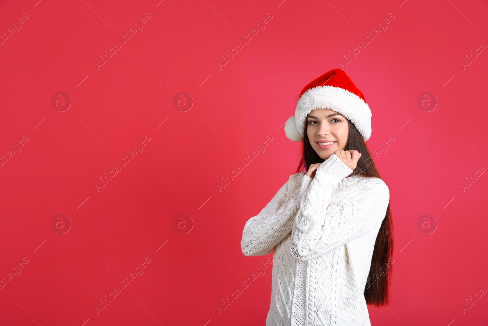 Photo of Young beautiful woman in Santa hat on color background. Christmas celebration