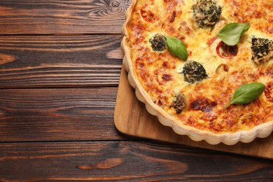 Delicious homemade vegetable quiche on wooden table, top view. Space for text