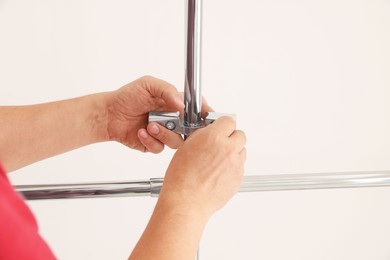 Photo of Worker installing new metal pipes indoors, closeup