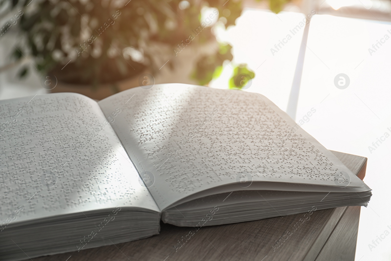 Photo of Book with Braille text on table, closeup. Education for blind people