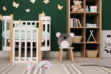 Photo of Beautiful baby room interior with comfortable crib and toys