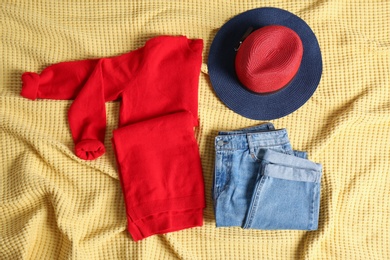 Photo of Flat lay composition with cashmere sweater, hat and jeans on soft plaid