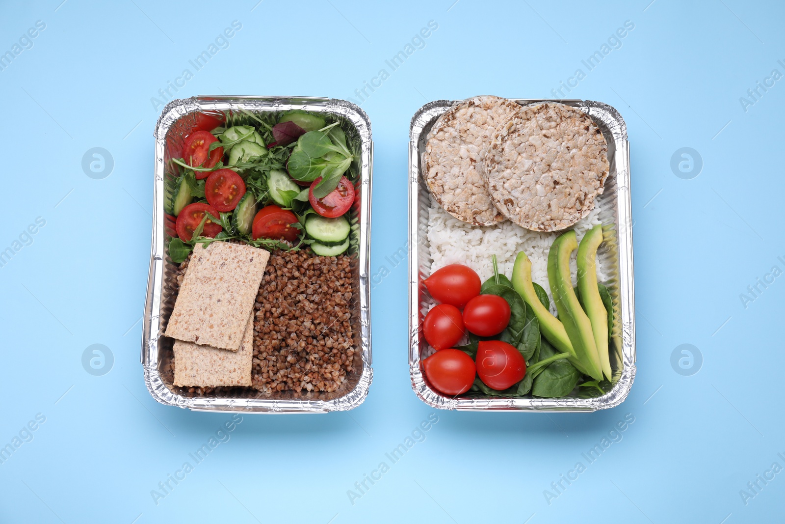 Photo of Containers with different fresh products on light blue background, flat lay