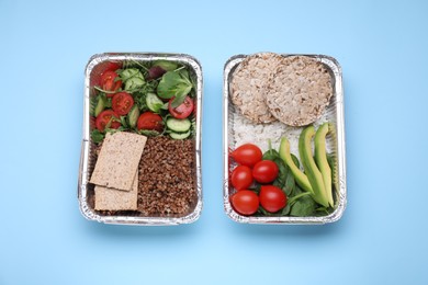 Containers with different fresh products on light blue background, flat lay