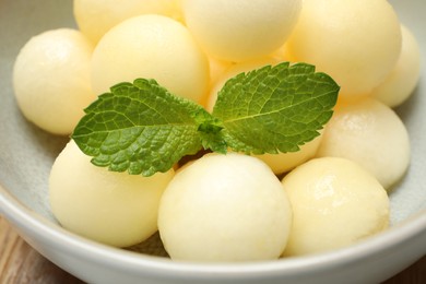 Photo of Melon balls with mint in bowl, closeup
