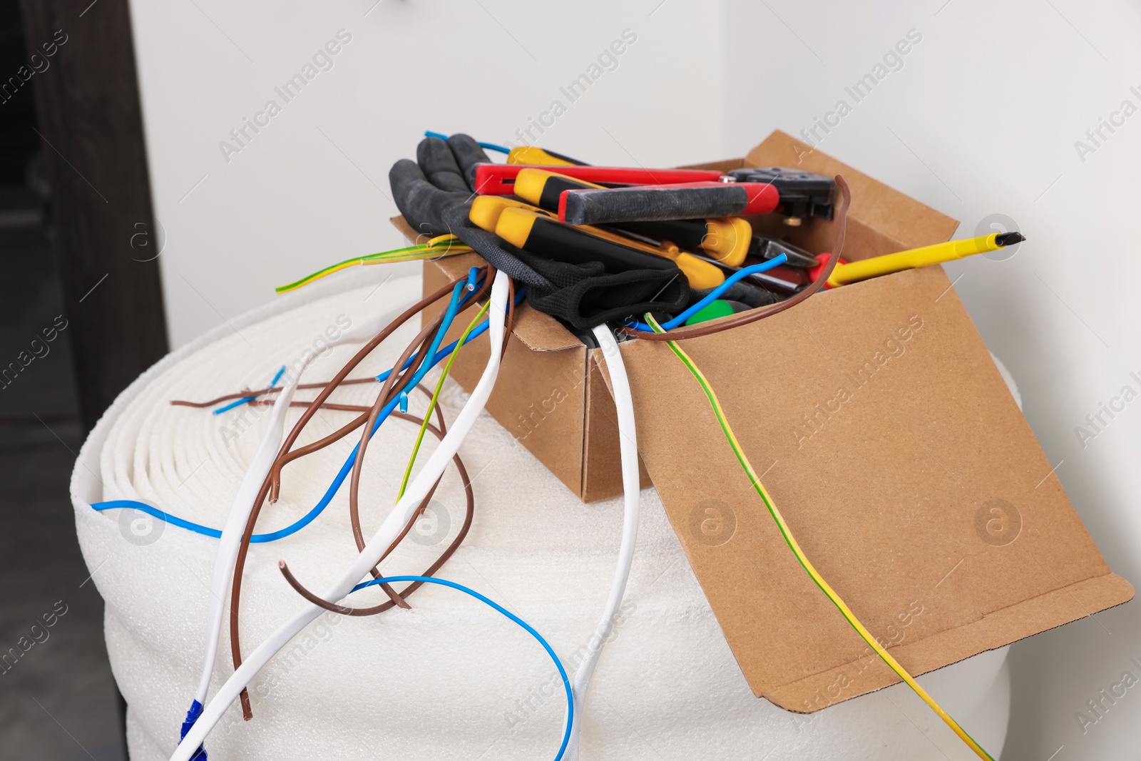 Photo of Different tools and cables in paper indoors. Installation of electrical wiring