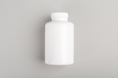 Photo of Blank white pill bottle on light grey background, top view