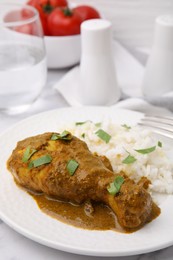 Photo of Delicious rice and chicken with curry sauce served on white table, closeup