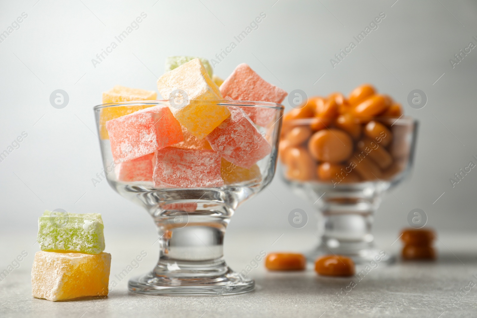 Photo of Dessert bowls filled with tasty sweets on light table