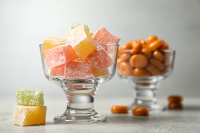 Dessert bowls filled with tasty sweets on light table