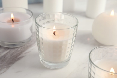 Photo of Burning candles in glass holders on table