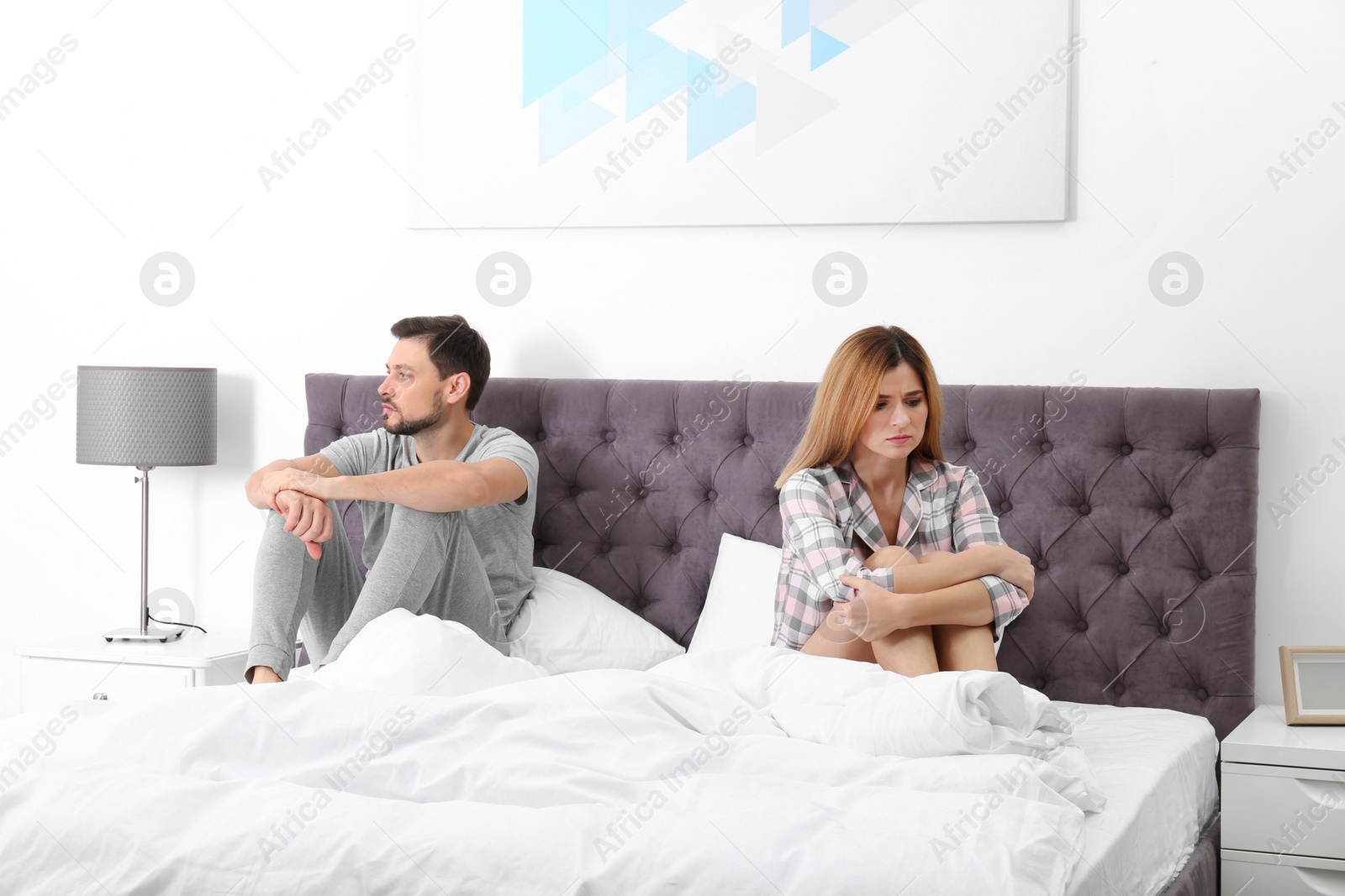 Photo of Couple with relationship problems ignoring each other in bedroom