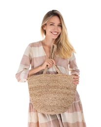 Beautiful young woman with stylish straw bag on white background