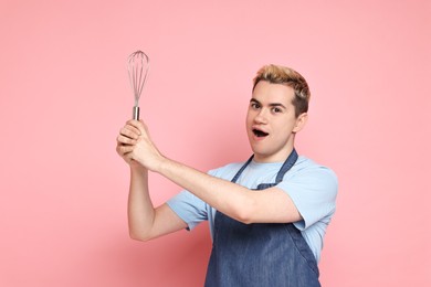 Photo of Portrait of happy confectioner holding whisk on pink background