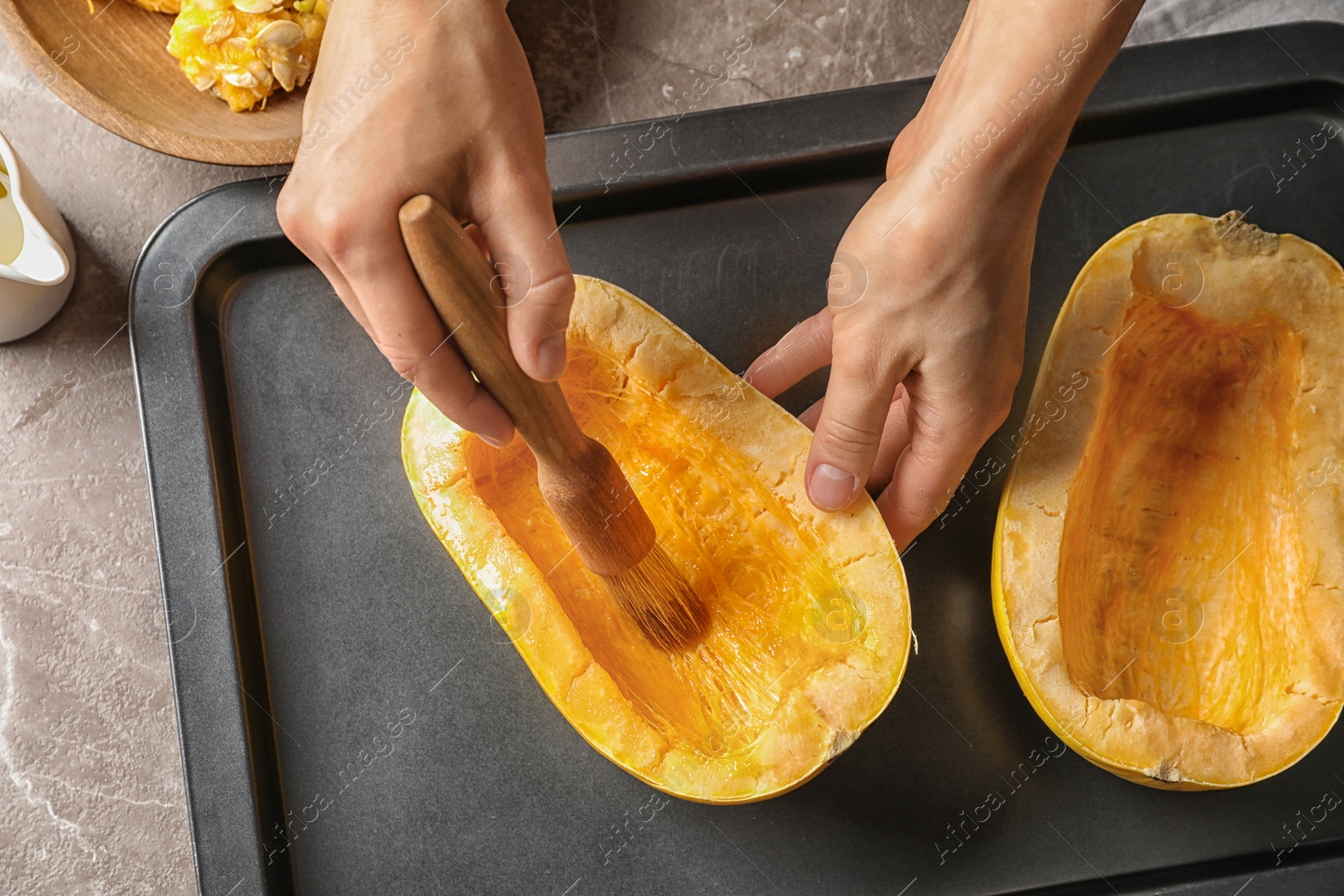 Photo of Woman preparing spaghetti squash on table, top view