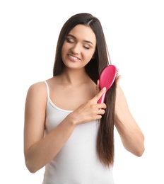 Beautiful young woman with hair brush on white background