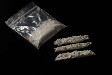 Photo of Drug addiction. Plastic bag with cocaine on black table