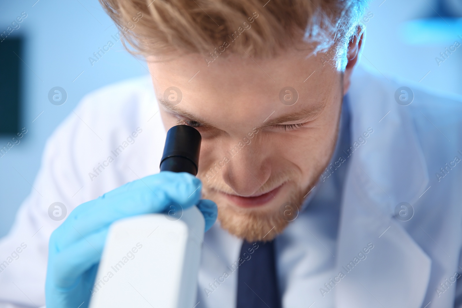 Photo of Male scientist using modern microscope in chemistry laboratory