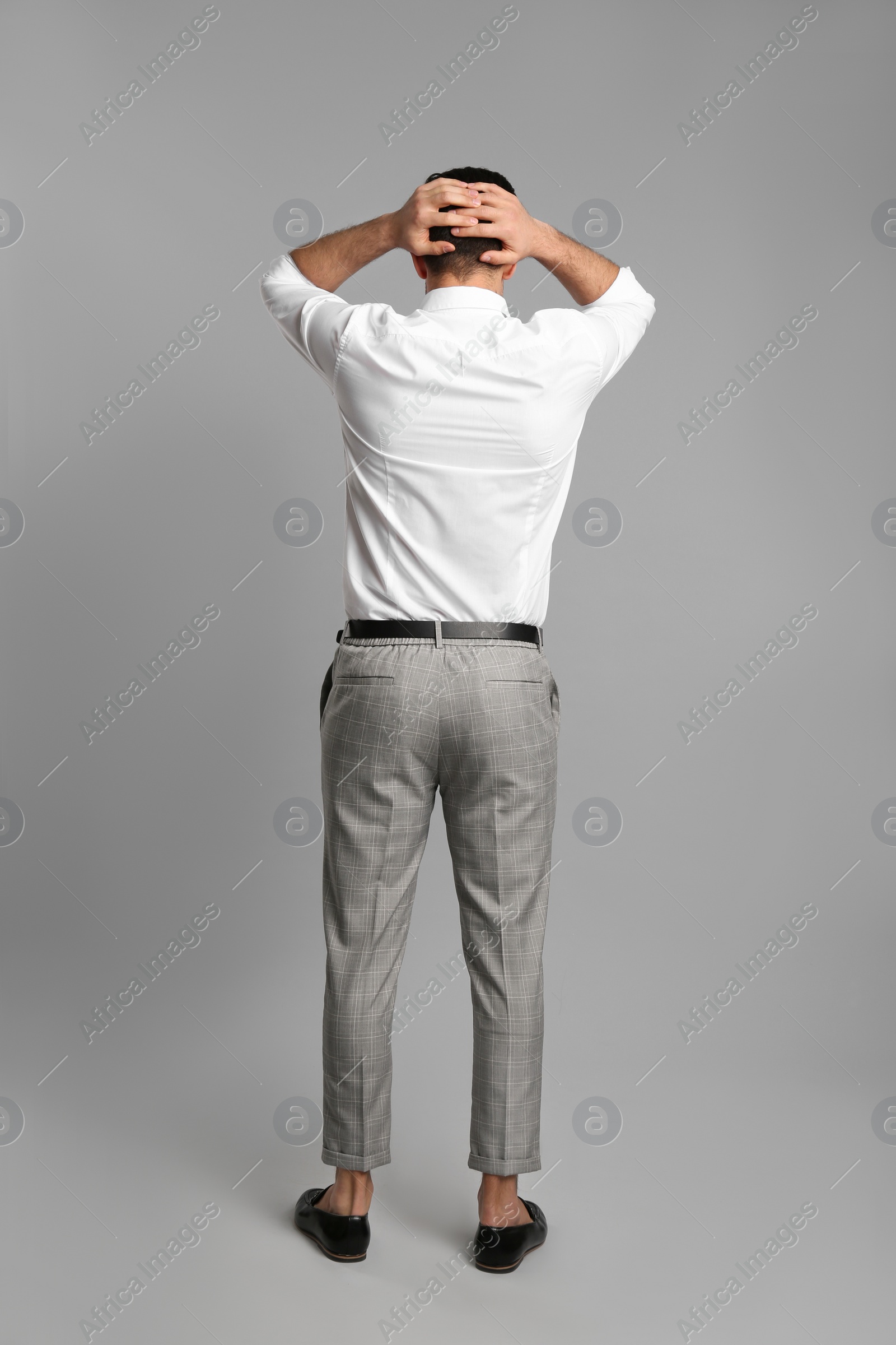 Photo of Businessman in formal clothes on grey background, back view