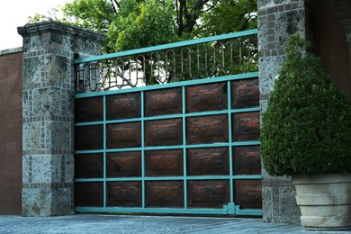 Photo of Closed metal gates and fence outdoors on summer day