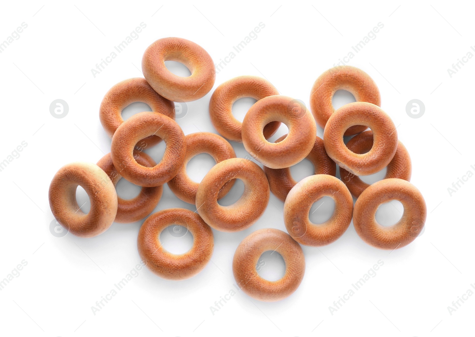 Photo of Many tasty dry bagels (sushki) isolated on white, top view