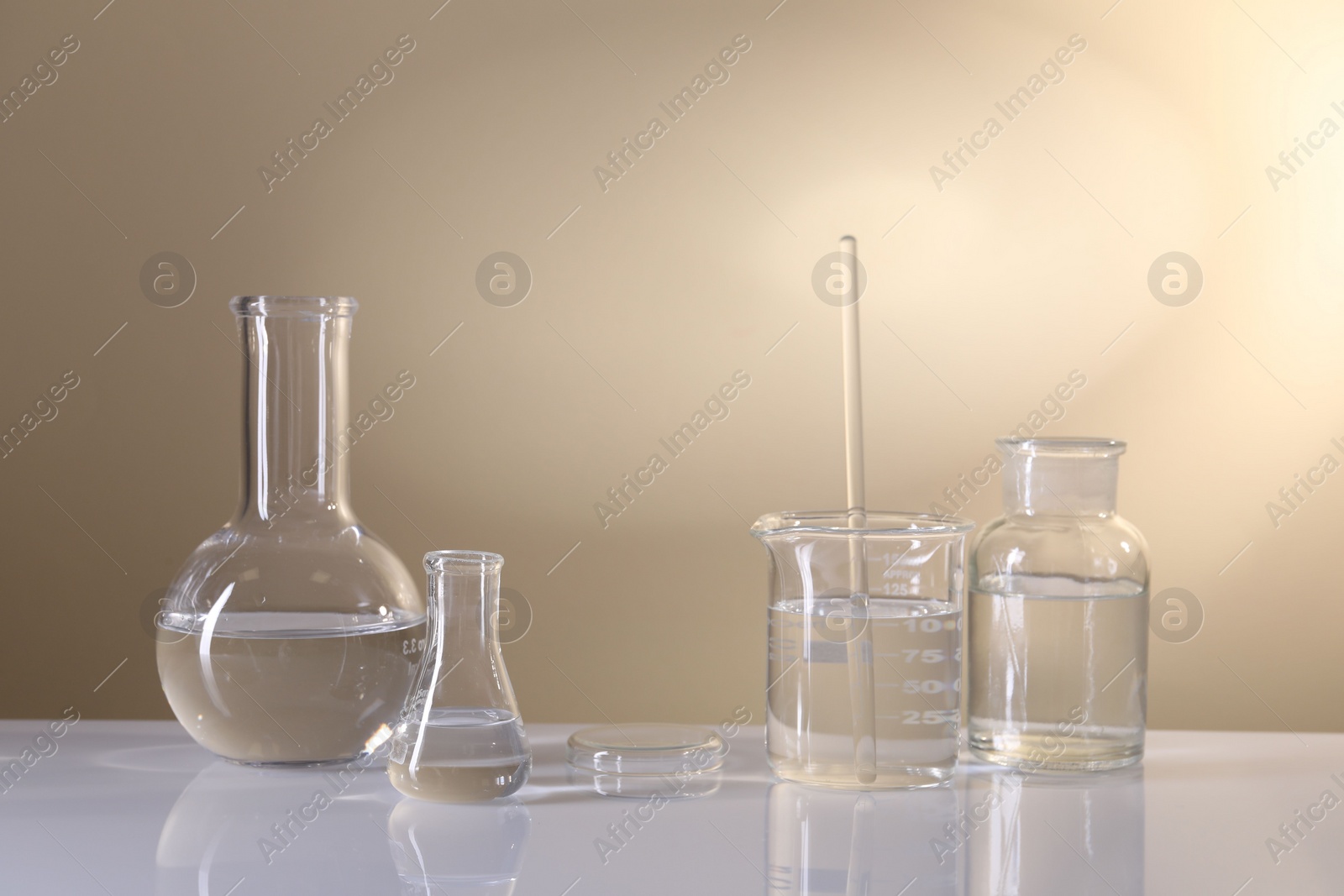 Photo of Laboratory analysis. Different glassware on table against beige background