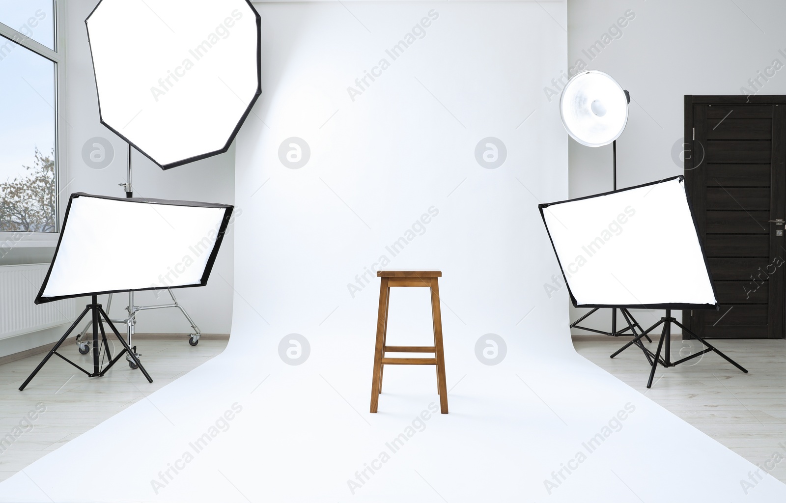 Photo of Interior of modern photo studio with bar stool and professional lighting equipment