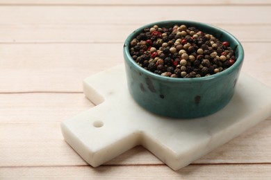 Aromatic spices. Different peppers in bowl on wooden table, space for text