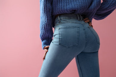 Photo of Woman wearing jeans on pink background, closeup