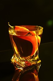Photo of Red hot chili pepper and vodka on dark table